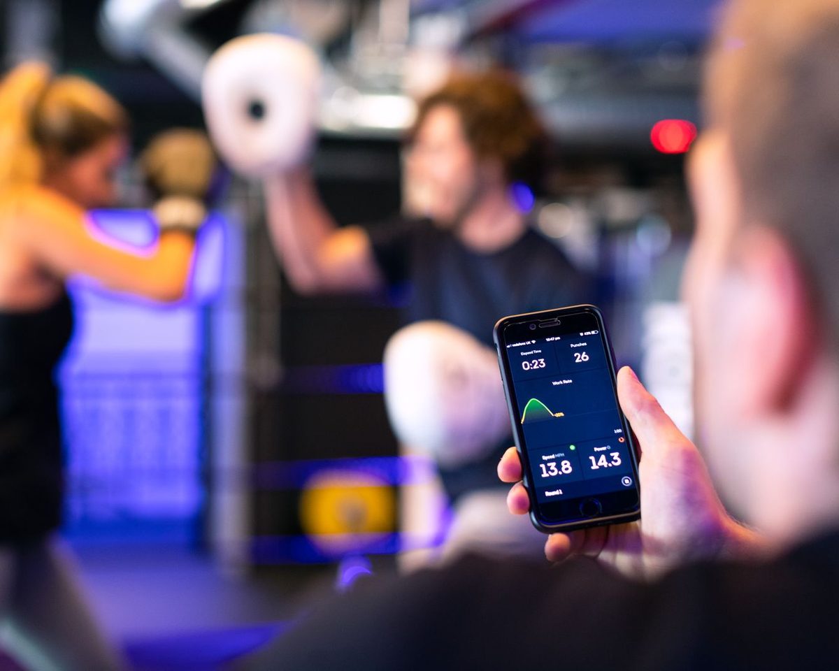Coach tracking a client's workout on a phone